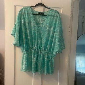 Size XL. Aqua shirt with white design. Mid tie detail. Flutter sleeves.